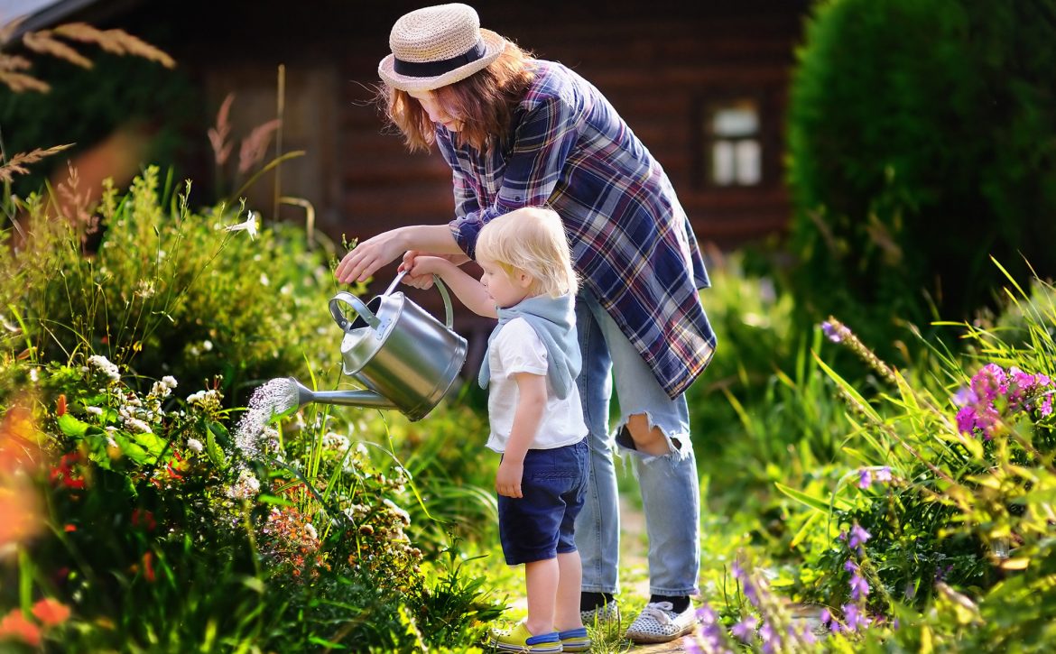 Cute,Toddler,Boy,And,His,Young,Mother,Watering,Plants,In